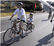 An image of person and a child riding a bike.