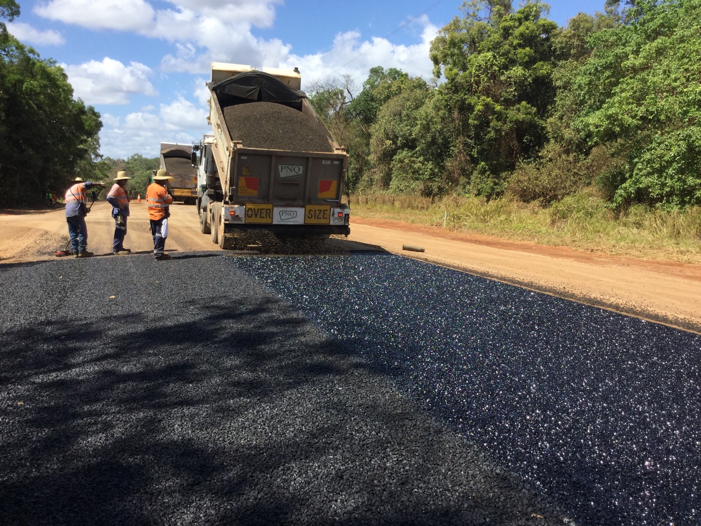 Workers with a truck laying road surface