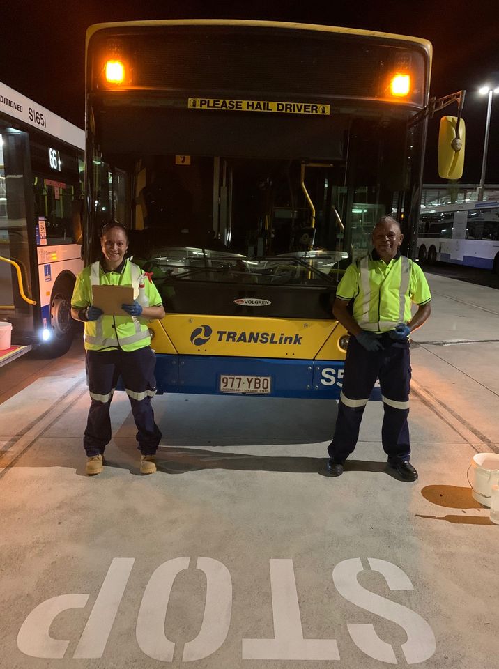 Two workers in front of a stopped bus