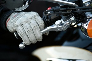 Photo of a motorcycle glove holding the handle and brake