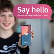 young woman holds her phone forward, with the Queensland Digital Licence app splash screen on it. A speech bubble reads ‘Say hello Queensland’s digital licence is here’