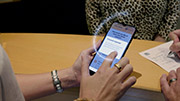 A hand touching a button on the phone screen. Text on the screen reads 'Consent required. You are about to share your information with a third party. Do you consent?