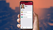 A hand holding a phone with a digital licence on the screen. A person's photo is in the top left of the screen. There are three options to choose from: Driver Licence, Photo ID, and Marine Licence.