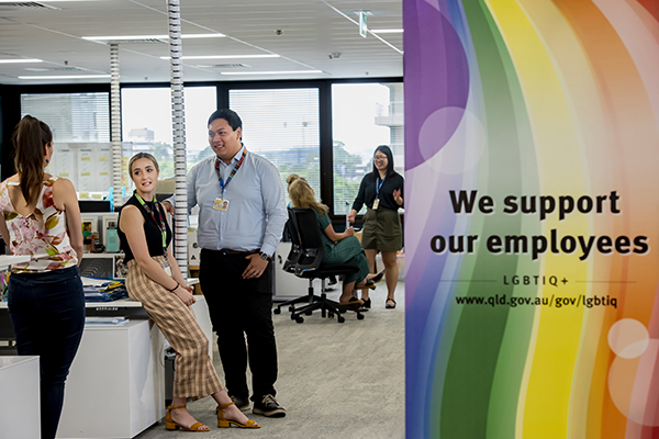 TMR employees meeting by a "we support employees - LGBTIQ+" poster