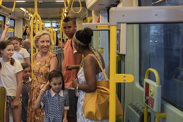 Passengers on Gold Coast tram service, image includes single parent with school children, young women travelling alone, culturally diverse families.