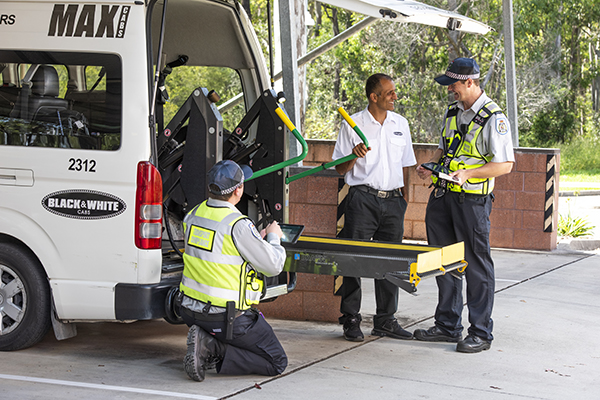 TMR transport inspectors undertaking inspection of wheelchair accessible lift on maxi cab