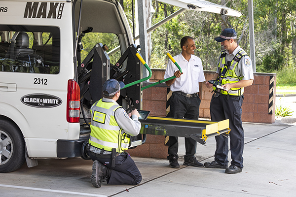 TMR transport inspectors  undertaking inspection of  wheelchair accessible lift on maxi cab