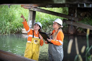 Two workers assessing under bridge