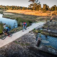 Bicycle riders crossing creek