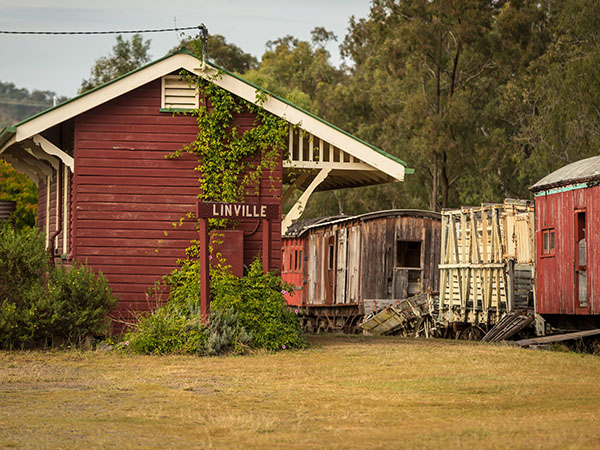 A red building with a sign that says 'Linville'. Next to it is an old train