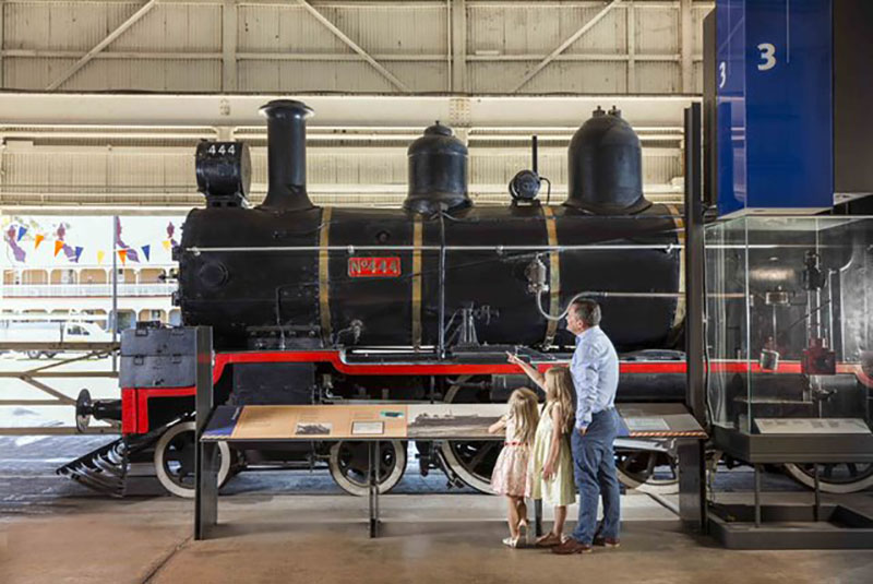 A young family looking at a train in a museum