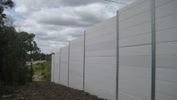 Plain concrete panels on a roadside noise barrier.