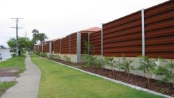 Weathered steel panels on a roadside noise barrier.