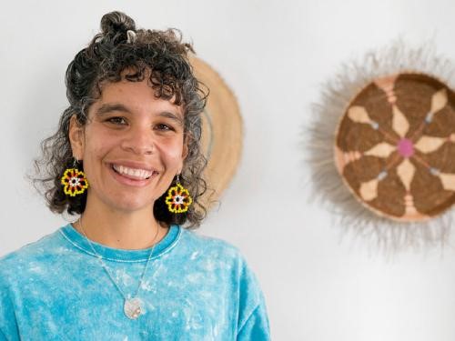A person smiling in front of artwork