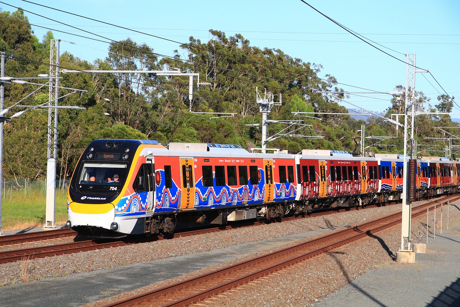 A New Generation Rollingstock train (with indigenous 'Travelling' artwork wrap) on the Gold Coast line.