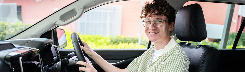 Person sitting in the drivers seat of a car