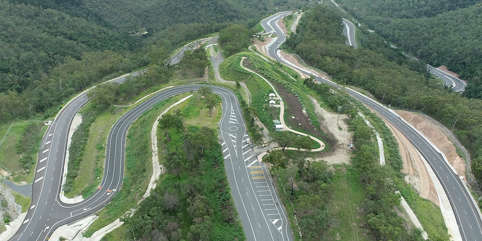 Winding roads between trees and mountains