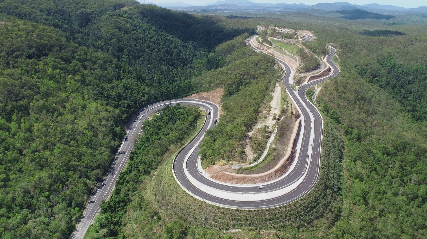 A winding road between trees and mountains