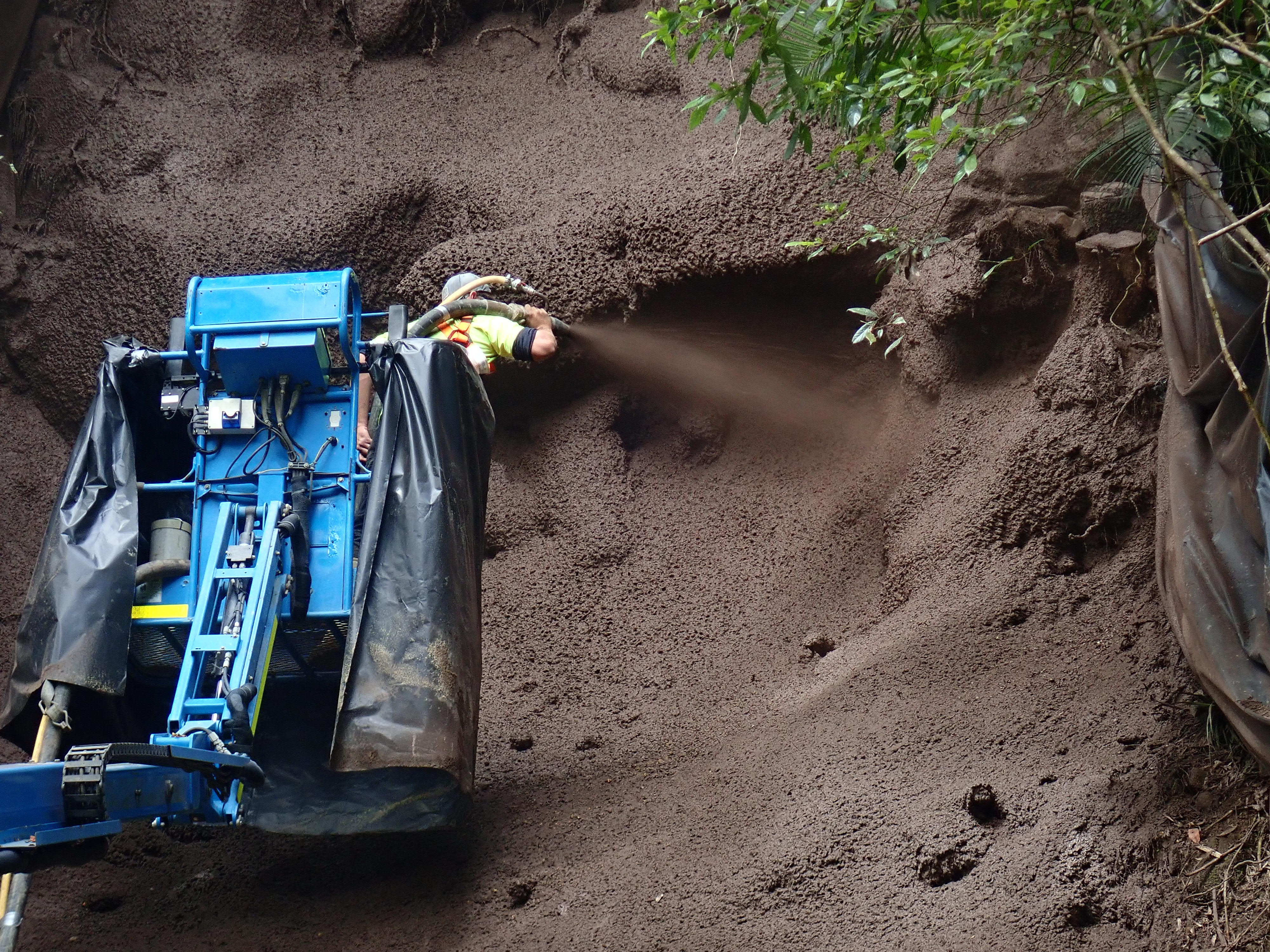 A machine spraying concrete to stabilise a slope at Mount Spec Road