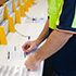Man using pen to complete form at desk in service centre