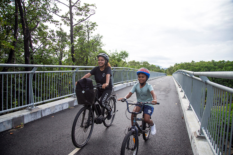 A woman and a child riding their bikes along Barr Creek Bridge. 