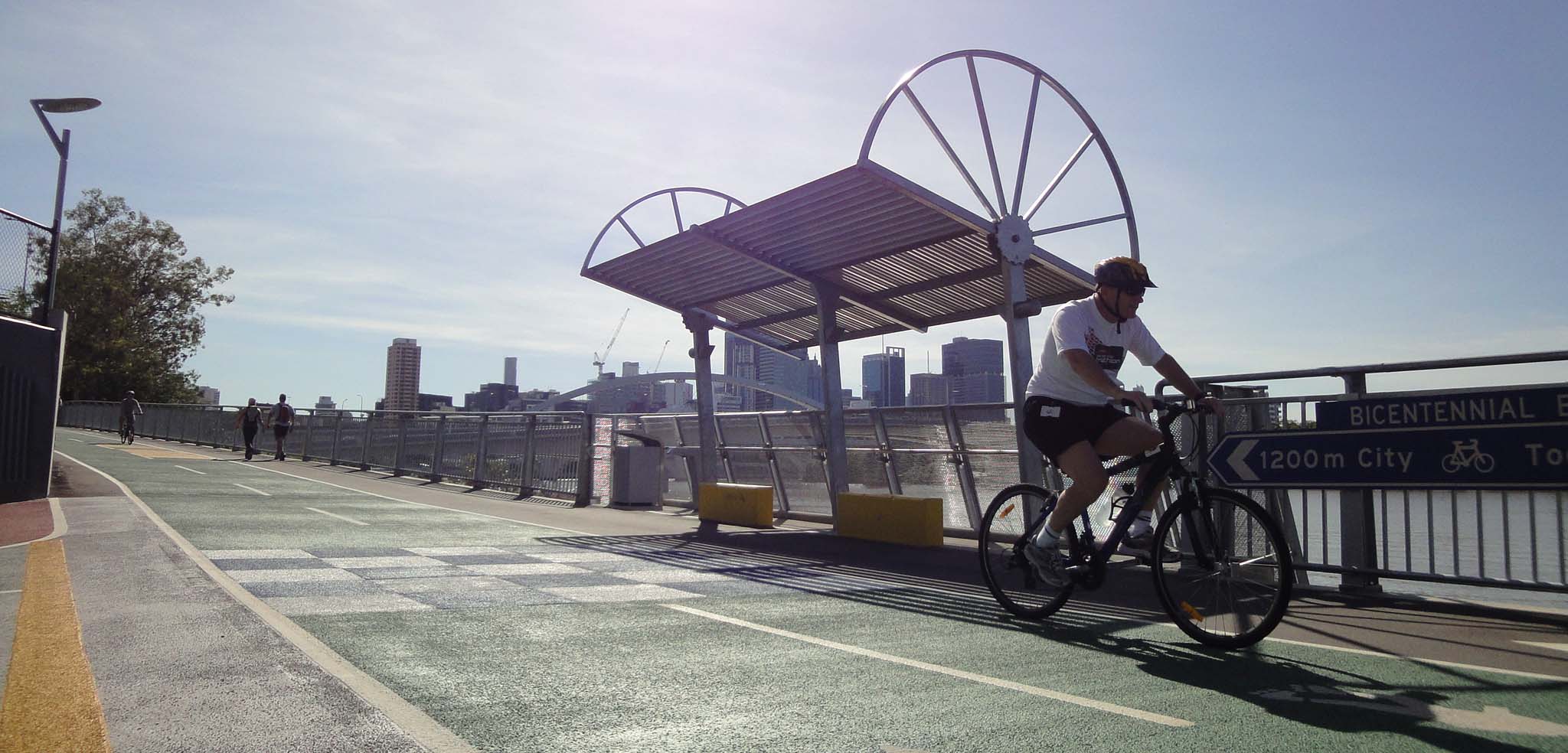 Image showing bike riding along Bicentennial Bikeway beside Brisbane River, with signage, seating and lighting