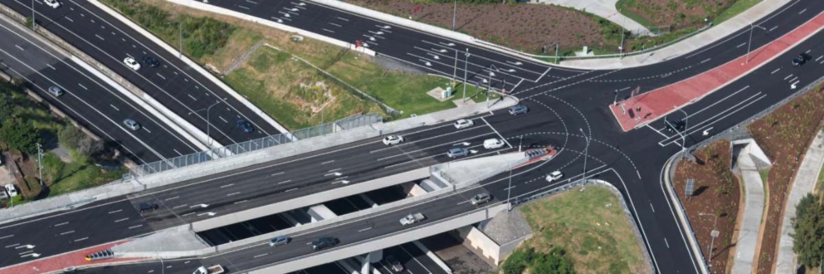Aerial view of a highway interchange. Separate paths run past and under the roads.