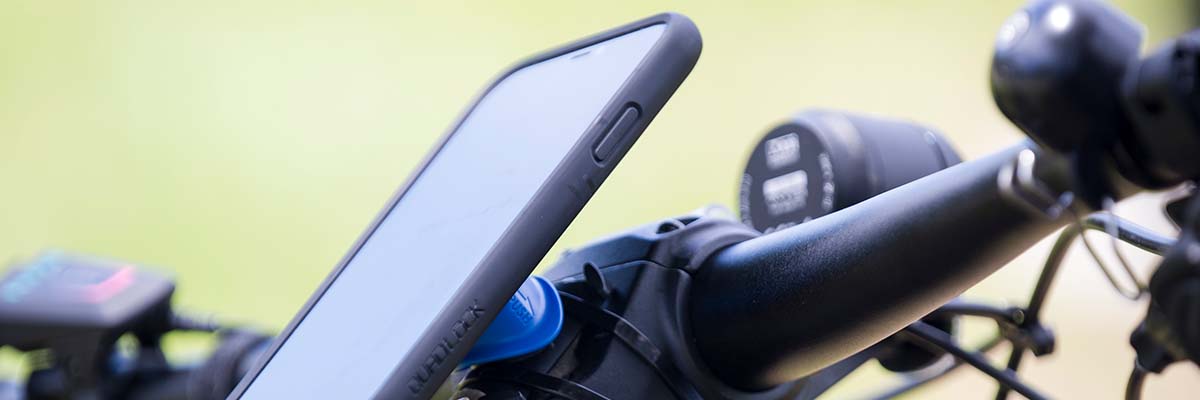 A mobile phone attached to bike handles.