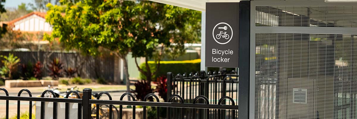 A sign saying ‘bicycle locker’ next to a caged area.
