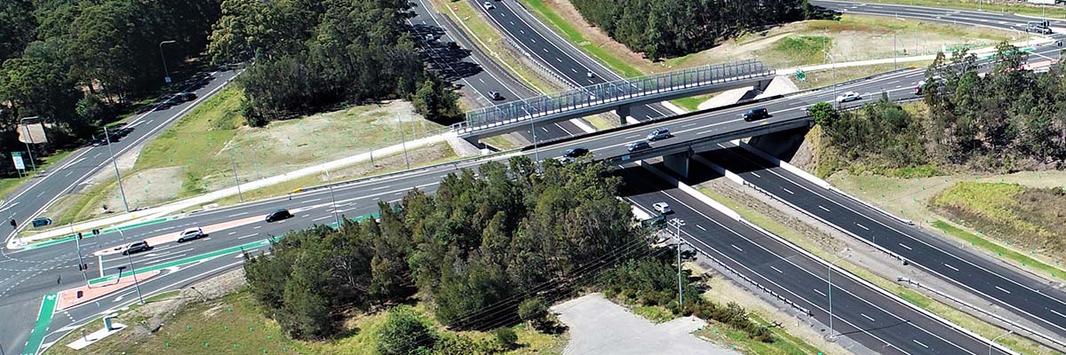 Aerial view of a highway interchange with a separate path running adjacent to a road overpass.